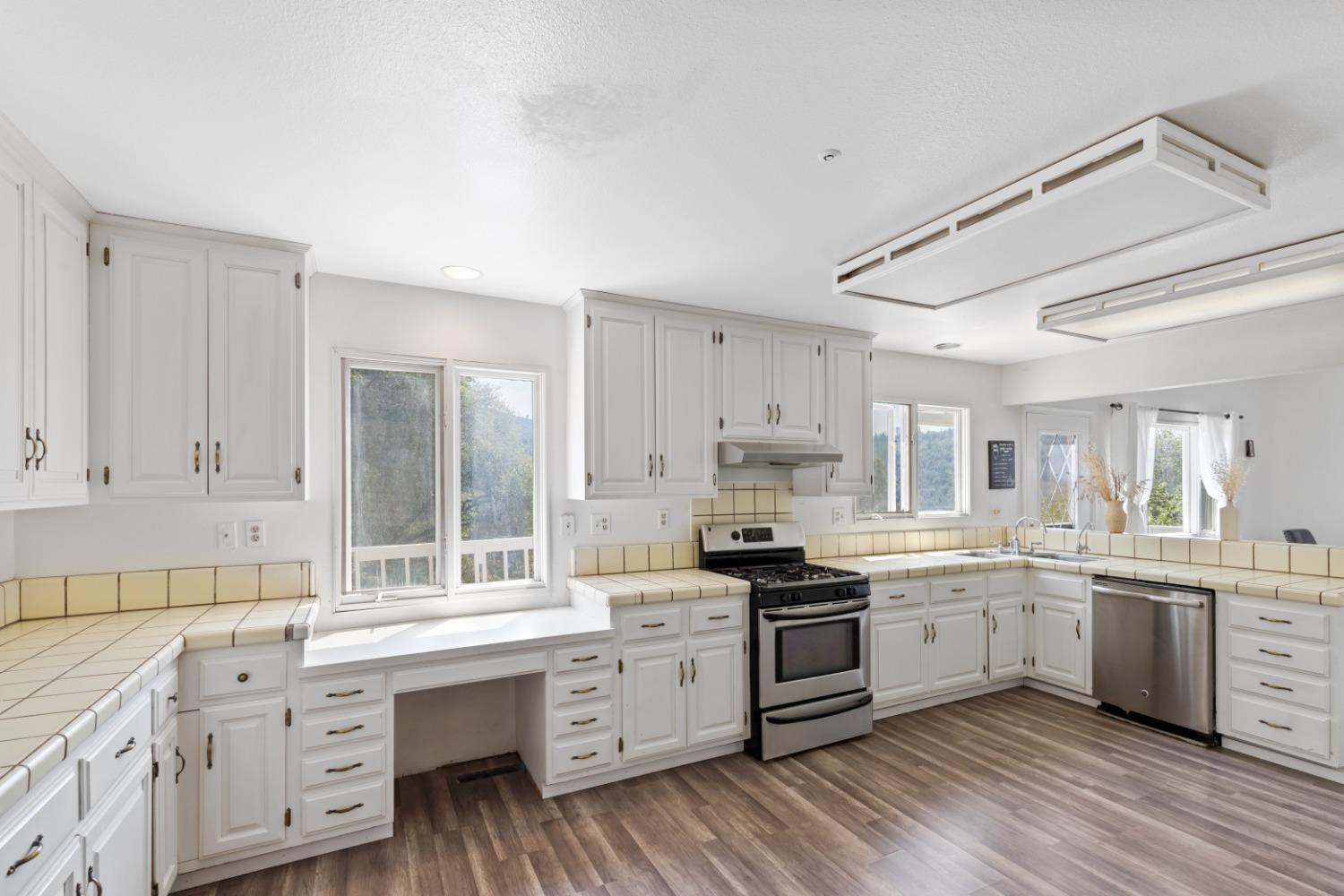 40707 Jean Road East Oakhurst, CA 93644 - Photo 10 of 44 a kitchen with granite countertop white cabinets and white appliances