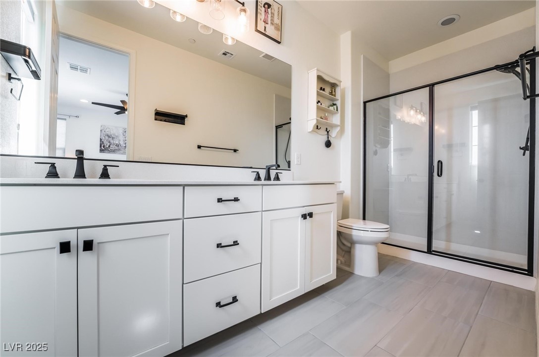 128 Kimberlite Drive Henderson, NV 89011 - Photo 18 of 55 Bathroom with double vanity, a shower stall, and light tile patterned floors