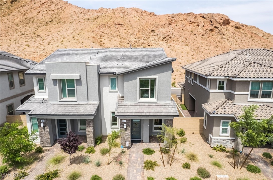 128 Kimberlite Drive Henderson, NV 89011 - Photo 42 of 55 View of front of home with stucco siding, stone siding, a mountain view, and a porch