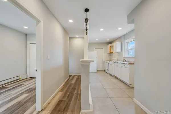 a open kitchen with white cabinets and white appliances