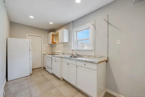 a bathroom with a granite countertop sink mirror and a toilet