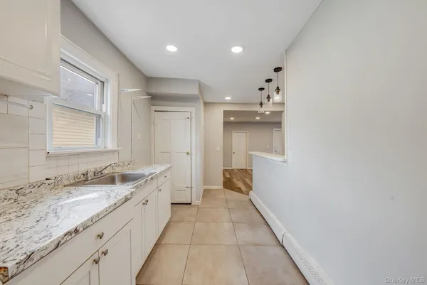 a large bathroom with a granite countertop sink and a mirror