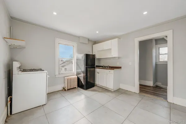 a kitchen with a refrigerator and white cabinets