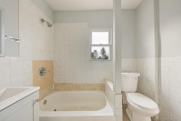 a white bath tub sitting next to a toilet