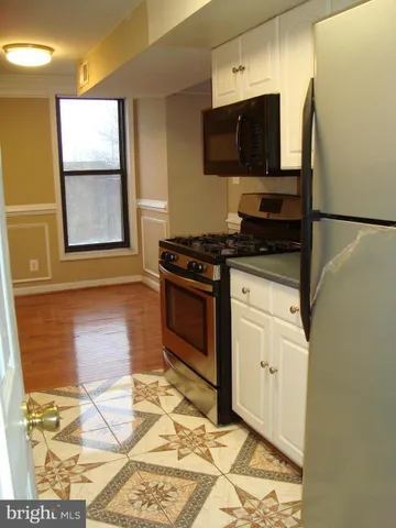 a kitchen with granite countertop a stove top oven cabinets a sink and a counter top space