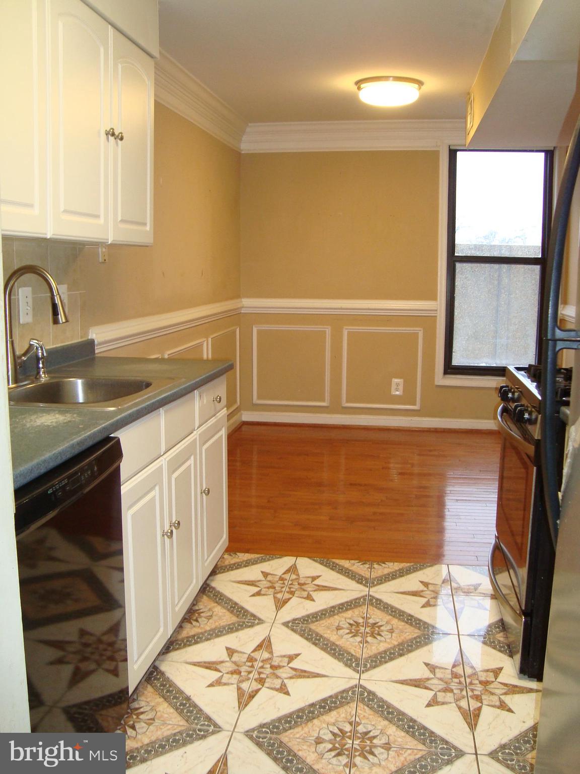 102 Duvall Lane, Unit 6202 Gaithersburg, MD 20877 - Photo 8 of 23 a kitchen with a sink stove and cabinets