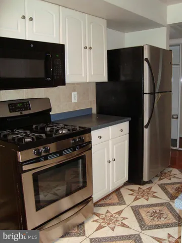 a kitchen with stainless steel appliances a stove a refrigerator and cabinets