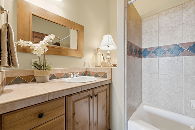 335 Bern Way Midway, UT 84049 - Photo 47 of 88 Bathroom vanity featuring a tile countertop, integrated sink, and wood-finish cabinetry