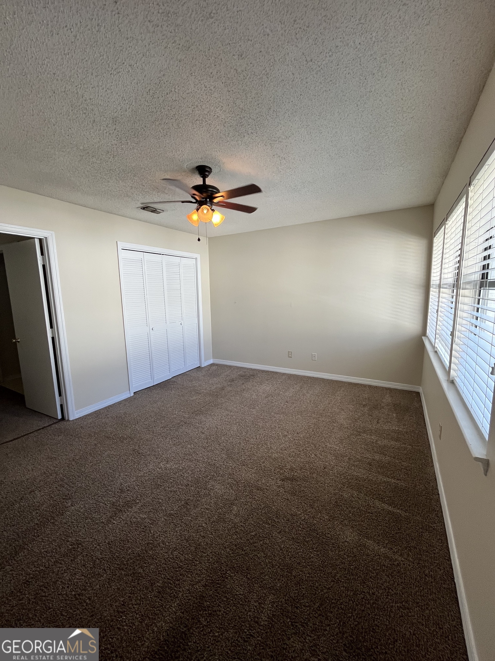 109 Inlet Reach Circle St. Marys, GA 31558 - Photo 12 of 16 an empty room with windows and chandelier fan