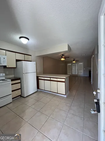 a kitchen with refrigerator and cabinets