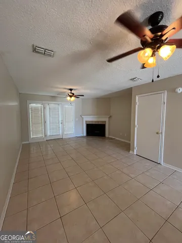 a view of empty room with a ceiling fan and window