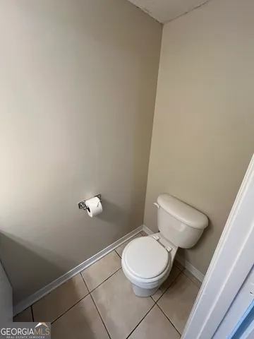 a white toilet sitting next to a white wall