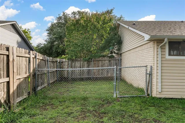 a backyard of a house with plants and tree