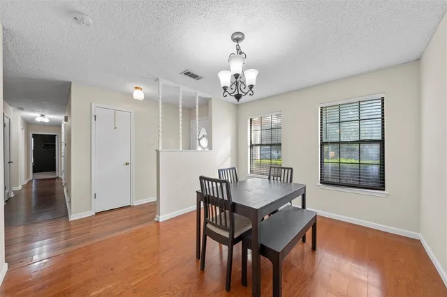 a view of a a dining room with furniture window and wooden floor