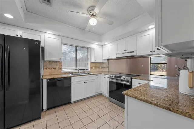 a kitchen with granite countertop a sink stainless steel appliances and cabinets
