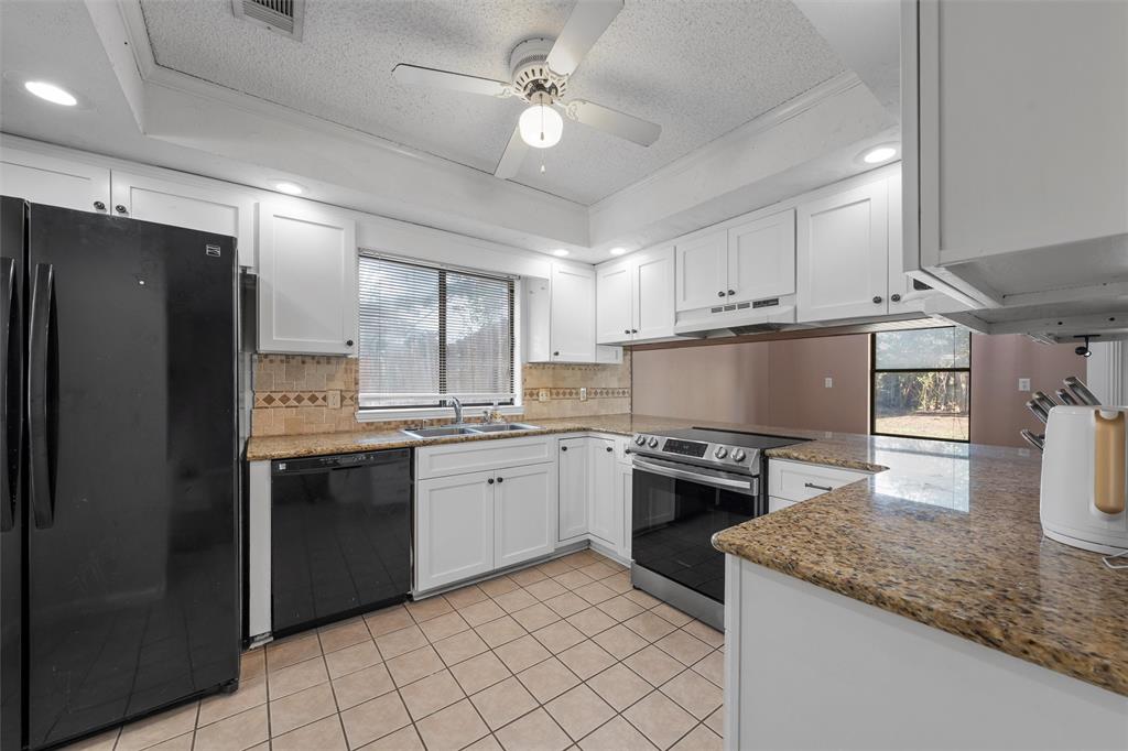 1010 December Drive Hewitt, TX 76643 - Photo 10 of 25 a kitchen with granite countertop a sink stainless steel appliances and cabinets