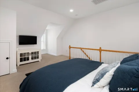 a bedroom with a bed and flat screen tv