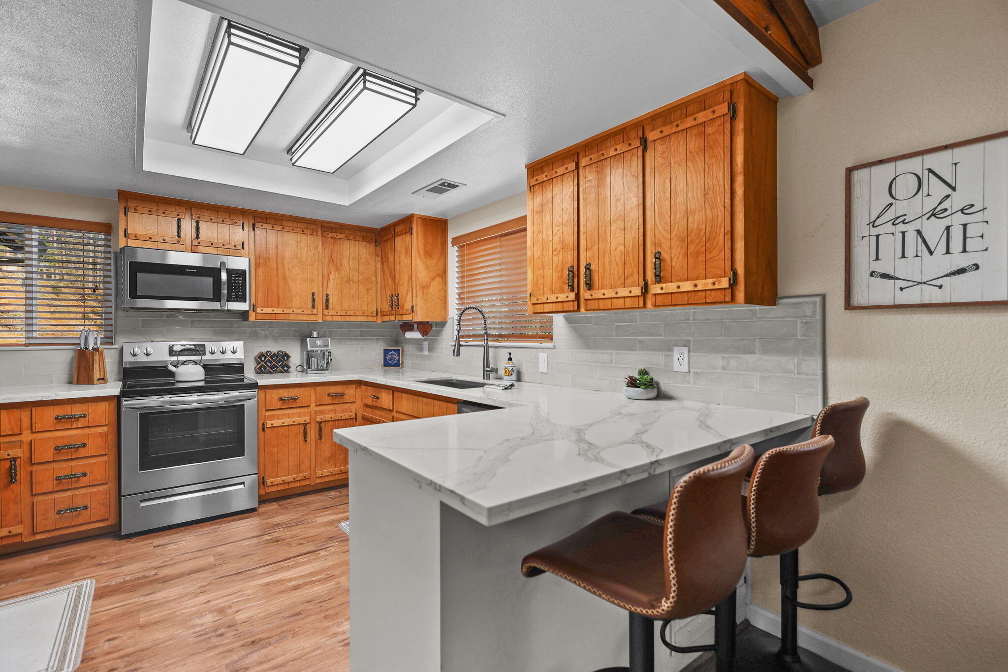 18260 Racoon Drive Lakehead, CA 96051 - Photo 6 of 23 a kitchen with stainless steel appliances granite countertop a sink a stove a refrigerator cabinets and a dining table with wooden floor
