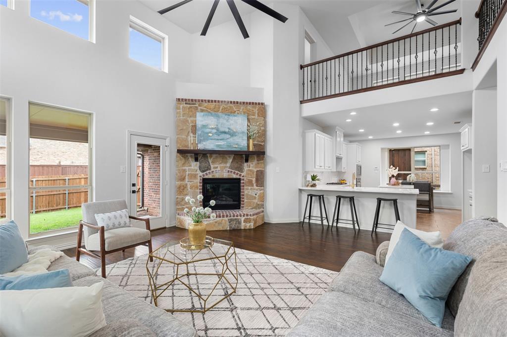11984 Del Rio Drive Frisco, TX 75035 - Photo 12 of 38 Living room featuring a towering ceiling, a ceiling fan, wood finished floors, and a healthy amount of sunlight