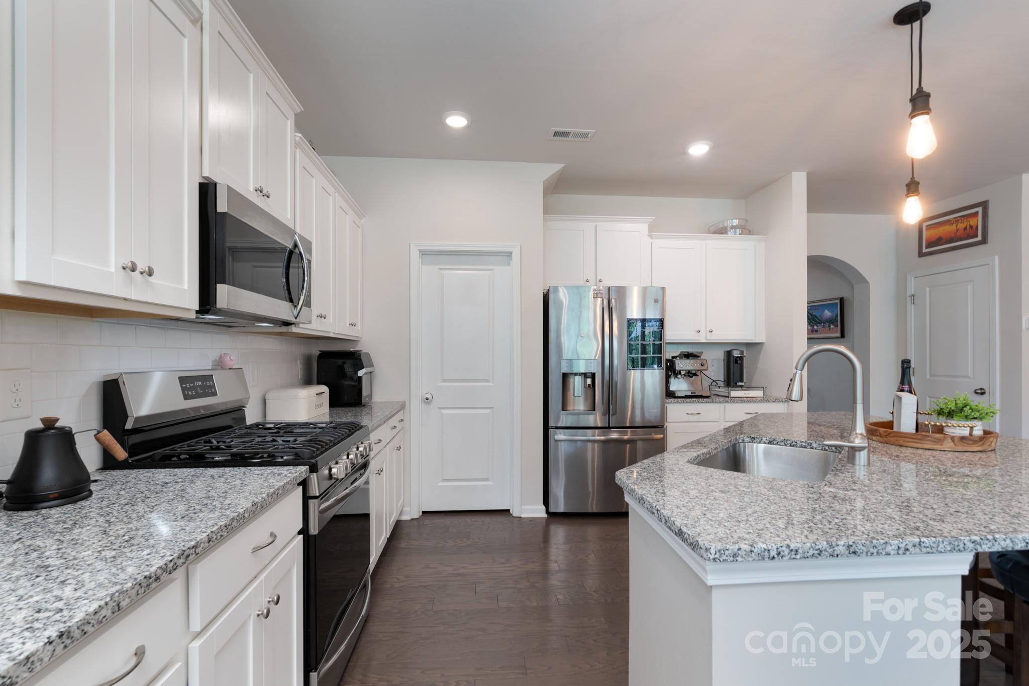 1782 Wildwood Terrace Trail Tega Cay, SC 29708 - Photo 11 of 47 a kitchen with stainless steel appliances granite countertop a sink refrigerator and microwave