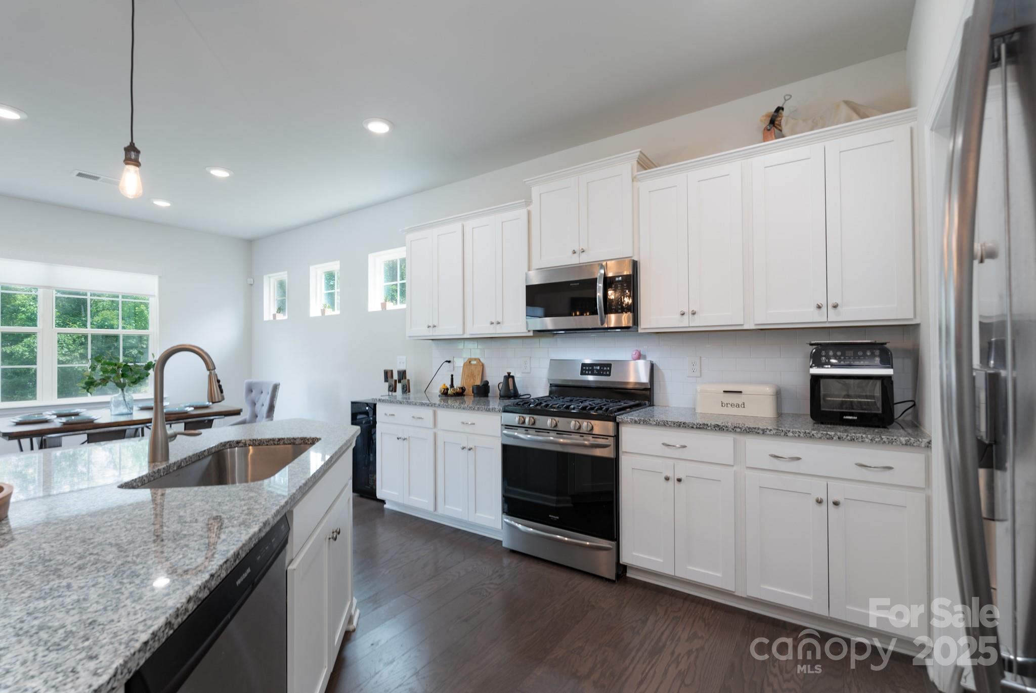 1782 Wildwood Terrace Trail Tega Cay, SC 29708 - Photo 13 of 47 a kitchen with stainless steel appliances granite countertop a sink a stove and cabinets