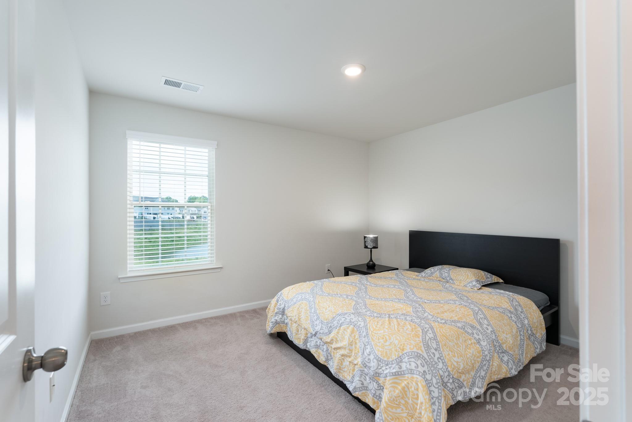 1782 Wildwood Terrace Trail Tega Cay, SC 29708 - Photo 22 of 47 a bed sitting in a bedroom next to a window