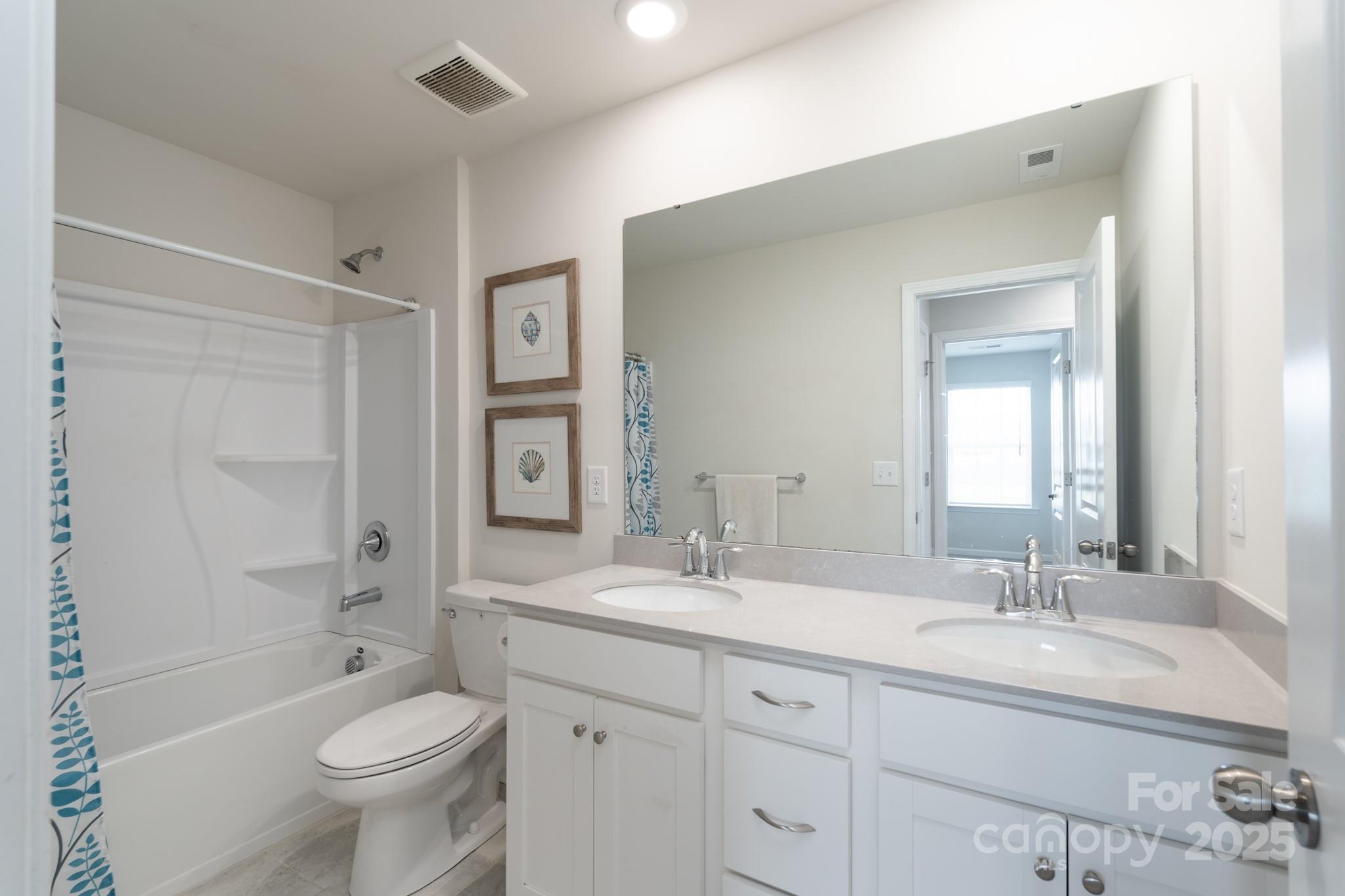 1782 Wildwood Terrace Trail Tega Cay, SC 29708 - Photo 23 of 47 a bathroom with a toilet a sink a mirror a bathtub and vanity