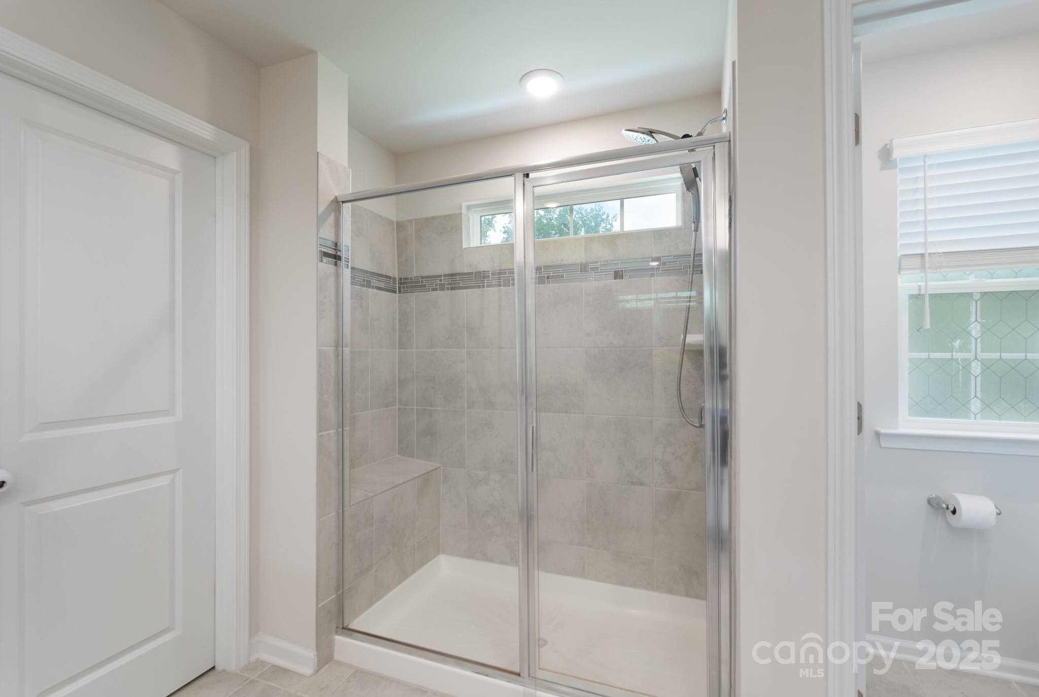 1782 Wildwood Terrace Trail Tega Cay, SC 29708 - Photo 27 of 47 a bathroom with a glass shower door