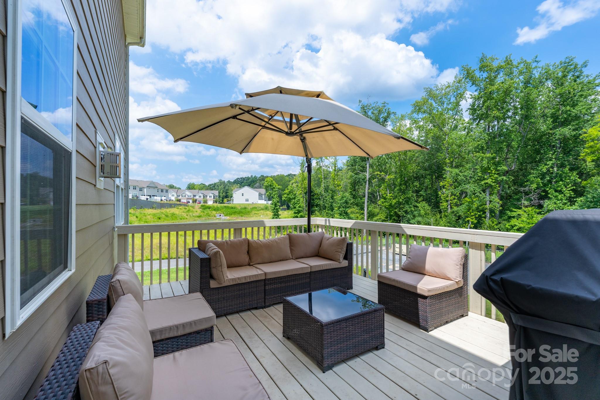 1782 Wildwood Terrace Trail Tega Cay, SC 29708 - Photo 36 of 47 a view of a patio with couches chairs under an umbrella