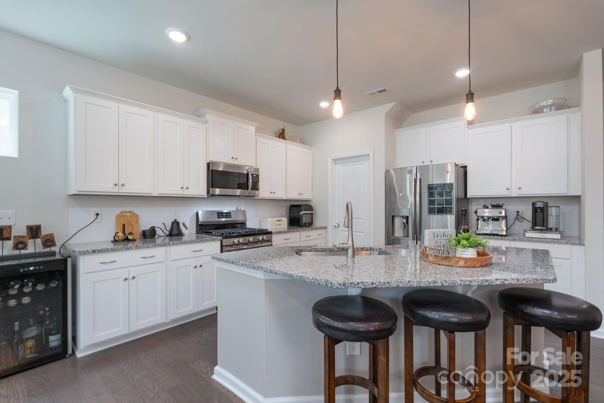 1782 Wildwood Terrace Trail Tega Cay, SC 29708 - Photo 10 of 47 a kitchen with stainless steel appliances granite countertop a sink a stove a refrigerator and chairs
