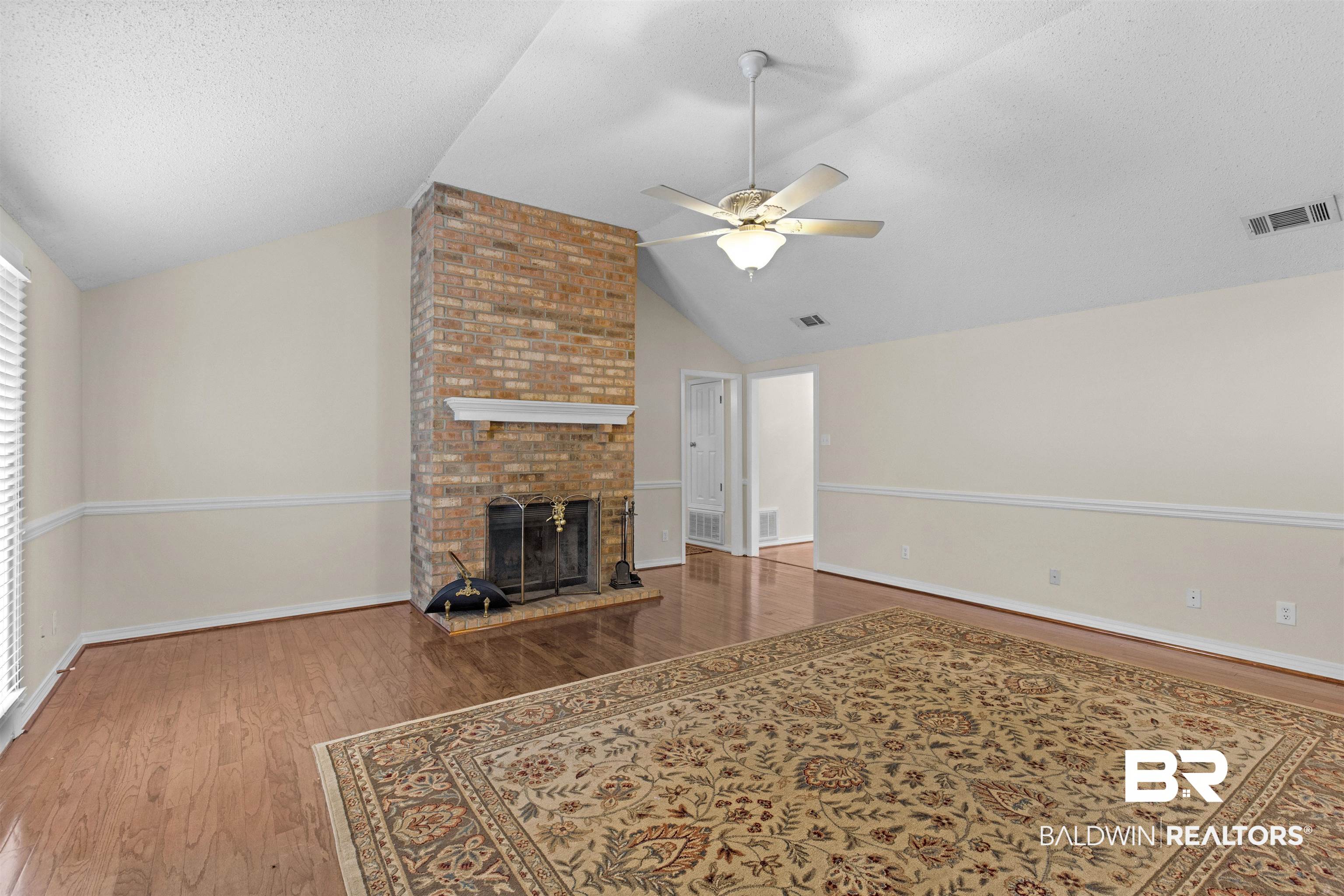 7225 Smithfield Road East Mobile, AL 36695 - Photo 10 of 27 Unfurnished living room with visible vents, wood finished floors, a ceiling fan, and vaulted ceiling