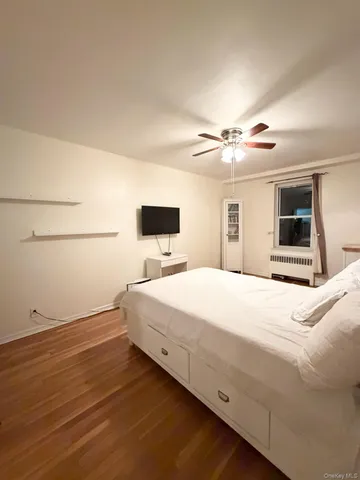 a spacious bedroom with a bed and a ceiling fan