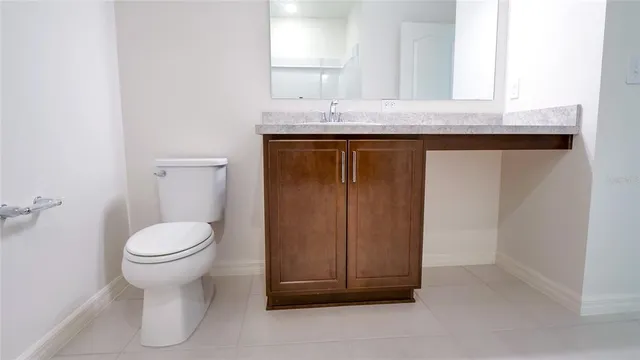 a bathroom with a granite countertop toilet sink and mirror
