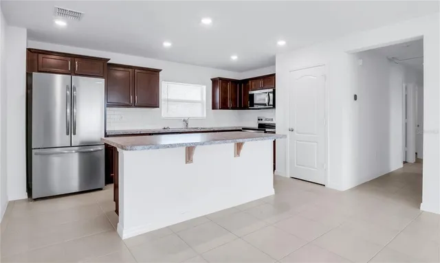 a kitchen with stainless steel appliances granite countertop a refrigerator sink and microwave