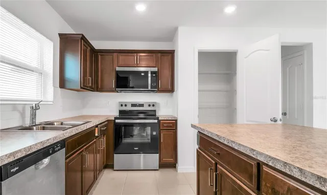 a kitchen with stainless steel appliances granite countertop a stove microwave and sink