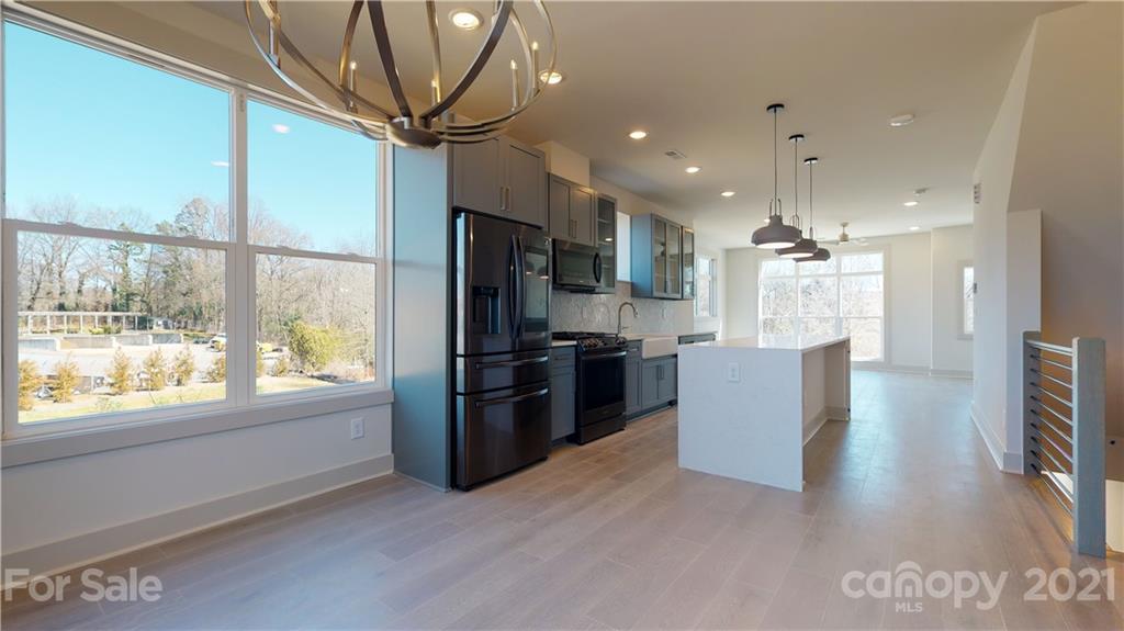 2335 Wesley Village Road, Unit 34 Charlotte, NC 28208 - Photo 11 of 40 a kitchen with stainless steel appliances kitchen island granite countertop a refrigerator and a stove top oven
