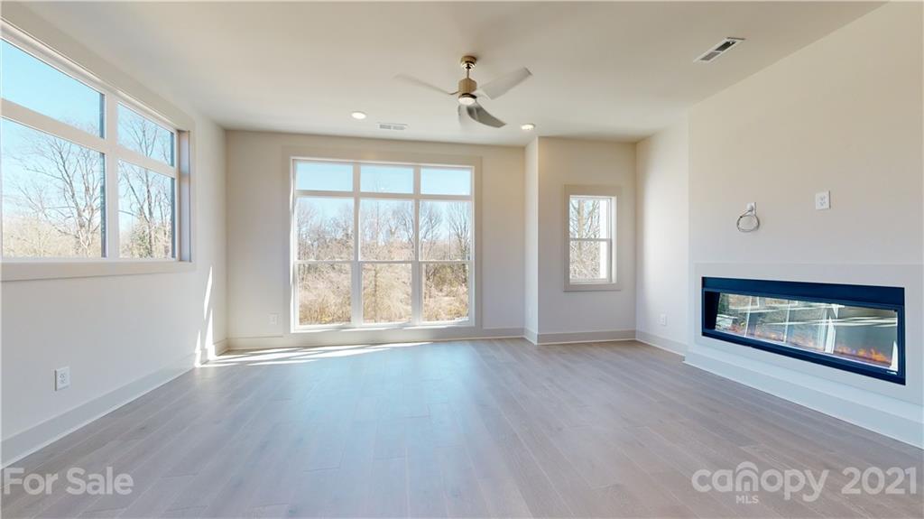 2335 Wesley Village Road, Unit 34 Charlotte, NC 28208 - Photo 14 of 40 a view of an empty room with a window and wooden floor