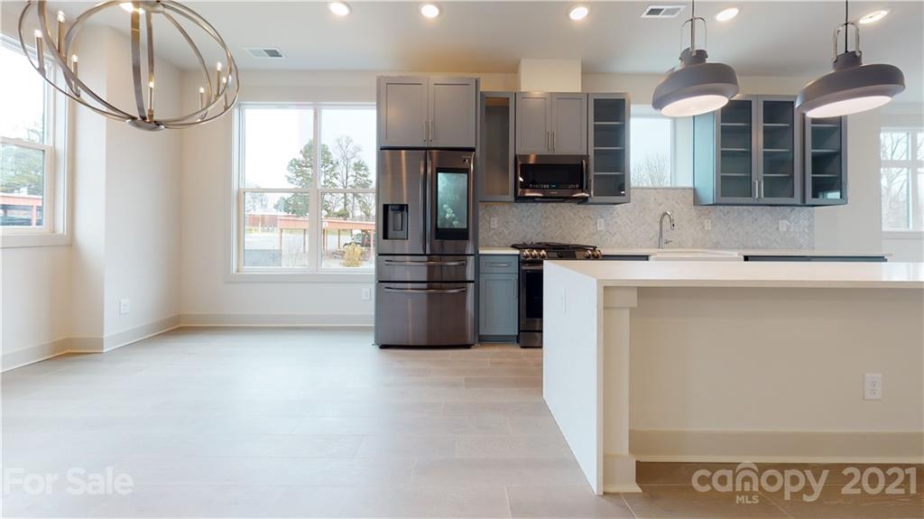 2335 Wesley Village Road, Unit 34 Charlotte, NC 28208 - Photo 31 of 40 a kitchen with stainless steel appliances granite countertop a sink a stove and a refrigerator
