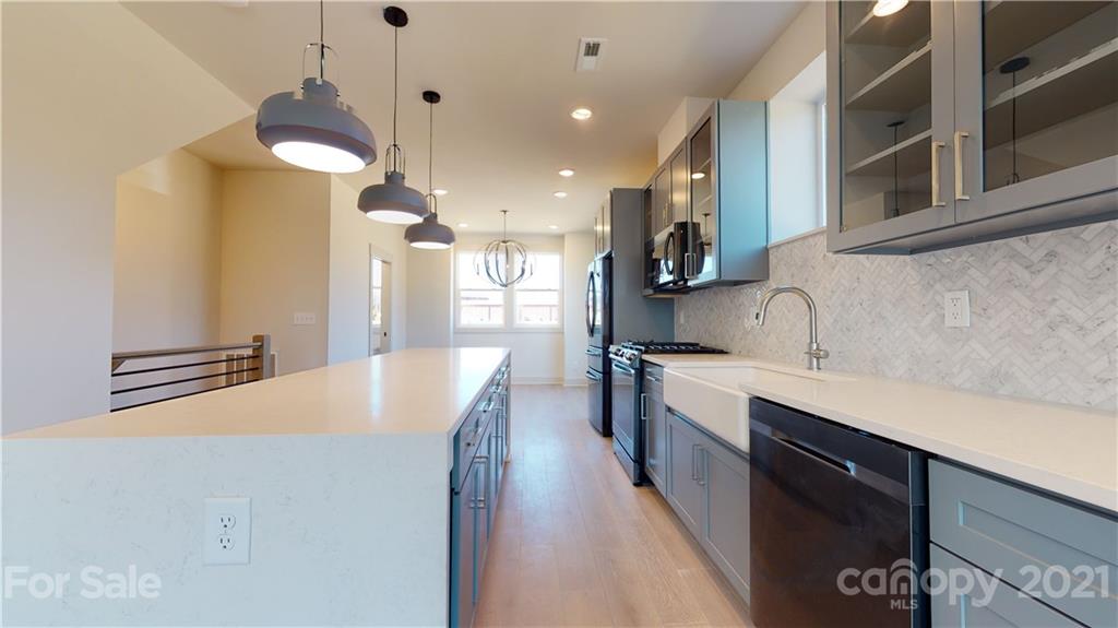 2335 Wesley Village Road, Unit 34 Charlotte, NC 28208 - Photo 5 of 40 a kitchen with a sink a counter top space stainless steel appliances and cabinets