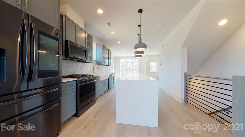 2335 Wesley Village Road, Unit 34 Charlotte, NC 28208 - Photo 10 of 40 a large kitchen with stainless steel appliances kitchen island granite countertop a refrigerator and a stove top oven