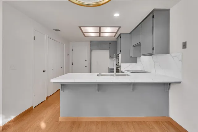 a kitchen with kitchen island a sink and a stove
