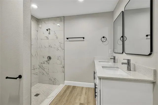 a bathroom with a shower sink and mirror