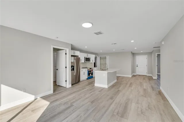 a view of a big room with wooden floor and windows