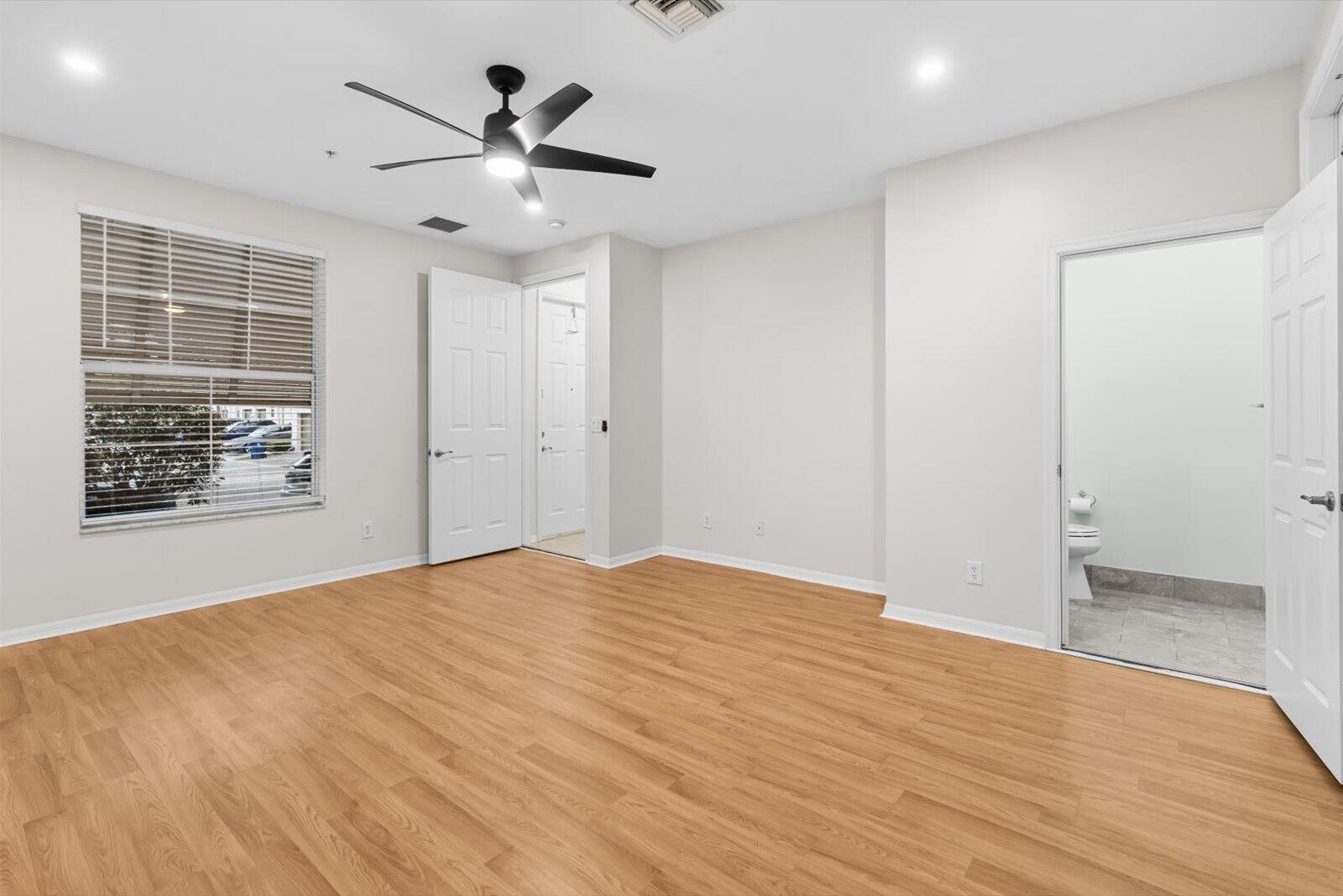 1460 Corbison Point Place Jupiter, FL 33458 - Photo 28 of 85 a view of an empty room with wooden floor and a ceiling fan