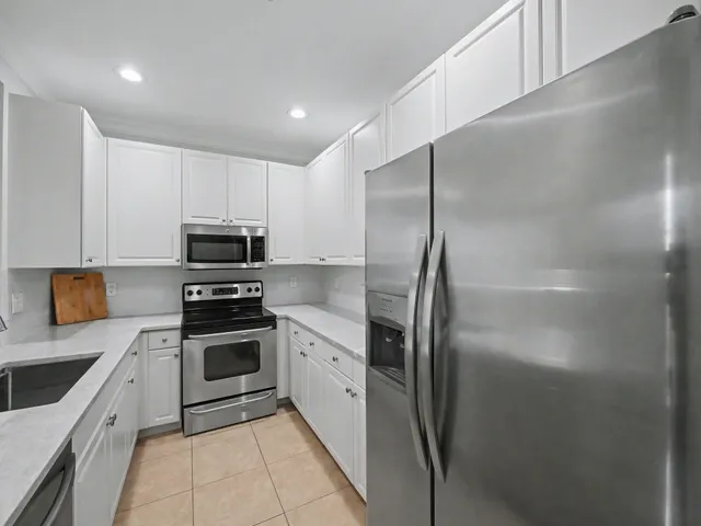 a kitchen with stainless steel appliances granite countertop grey cabinets a stove a sink and dishwasher