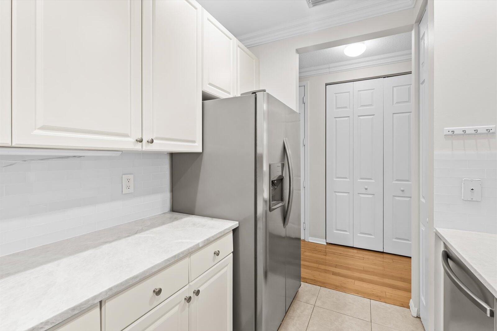 1460 Corbison Point Place Jupiter, FL 33458 - Photo 36 of 85 a kitchen with a refrigerator and cabinets