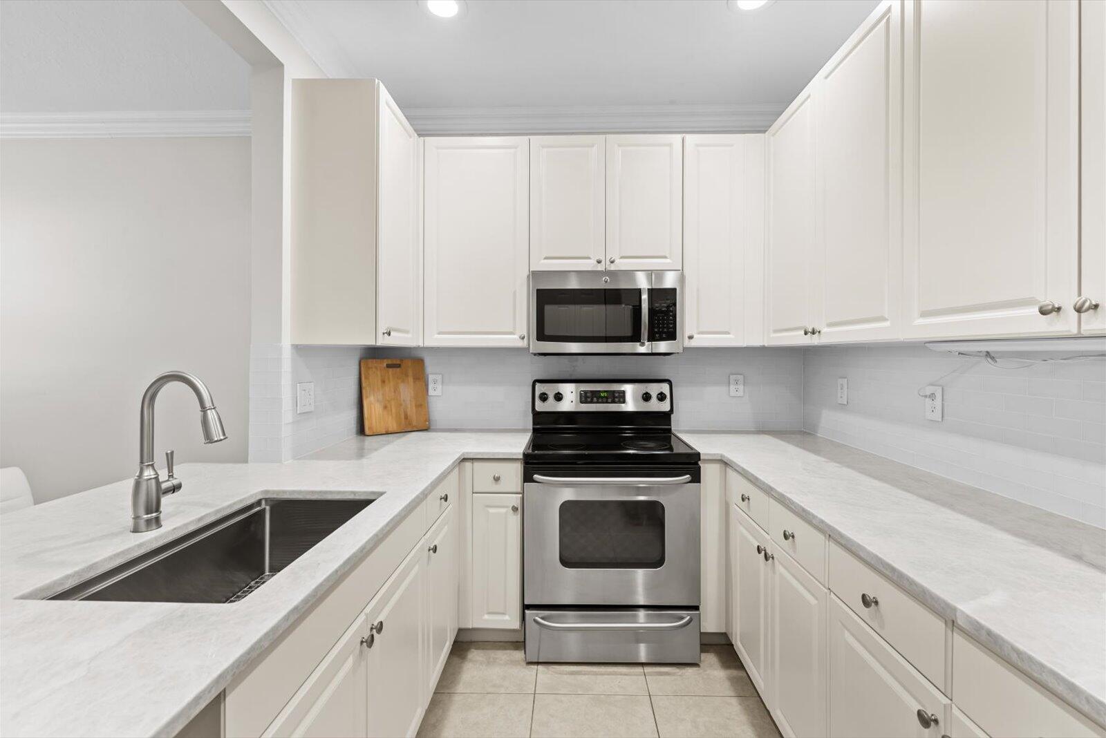 1460 Corbison Point Place Jupiter, FL 33458 - Photo 6 of 85 a kitchen with stainless steel appliances granite countertop grey cabinets a stove a sink and dishwasher