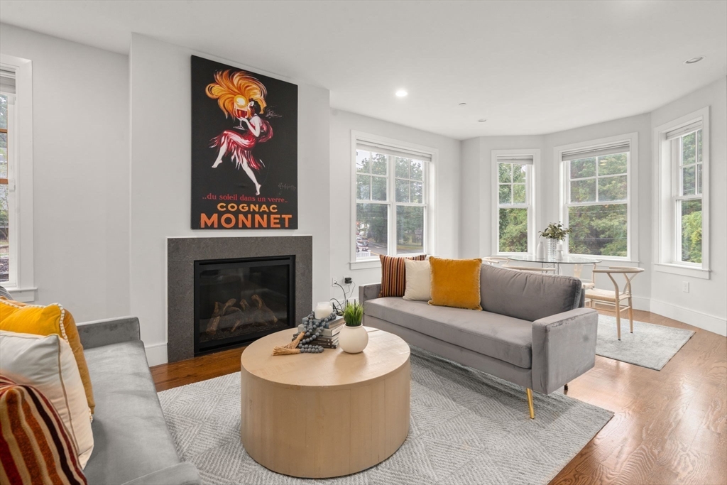 577 Baker Street, Unit 577 Boston, MA 02132 - Photo 3 of 22 a living room with furniture a fireplace and a large window
