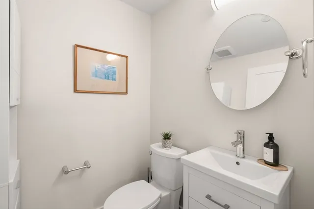 a bathroom with a toilet sink and mirror