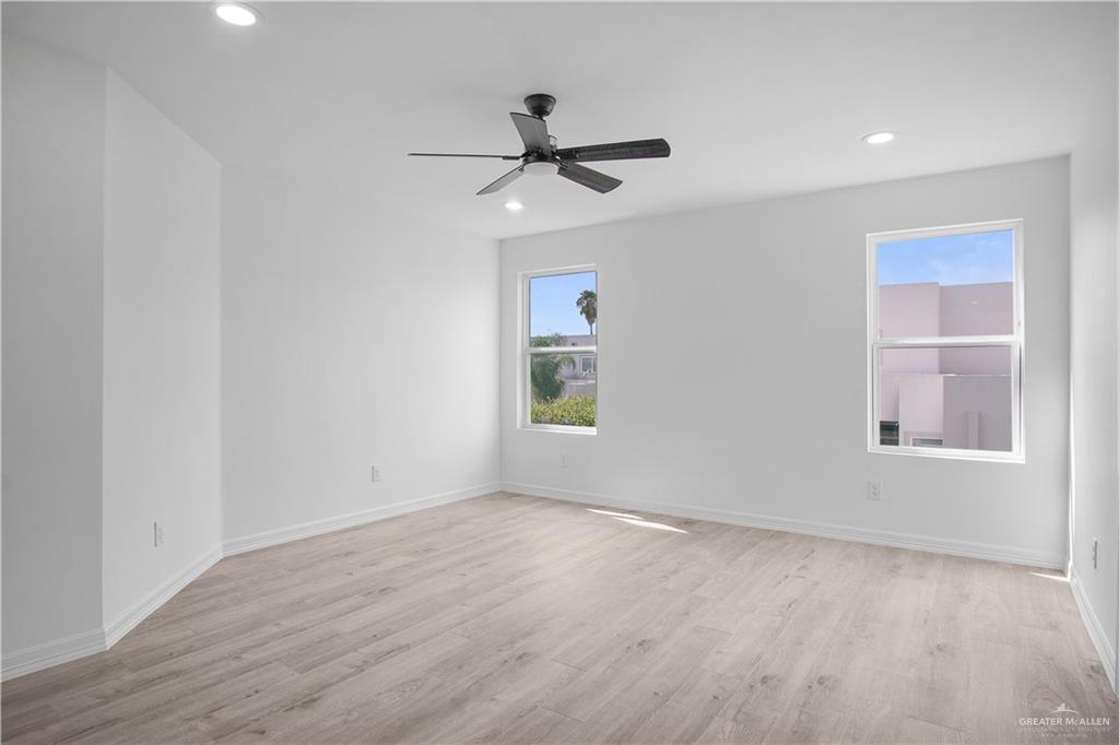 2310 Corales Street Mission, TX 78573 - Photo 11 of 23 an empty room with wooden floor ceiling fan and windows